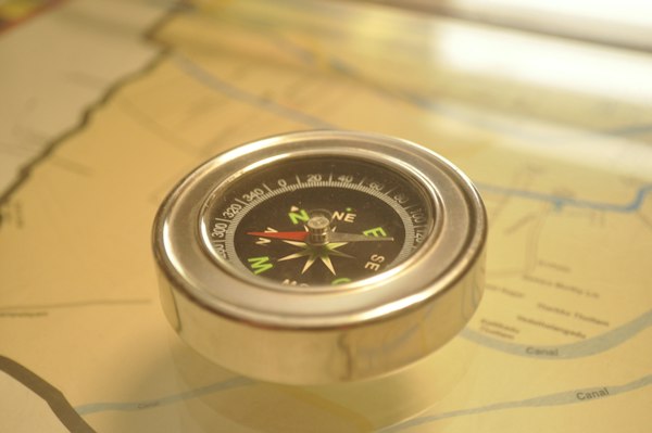 A brass compass resting on a map