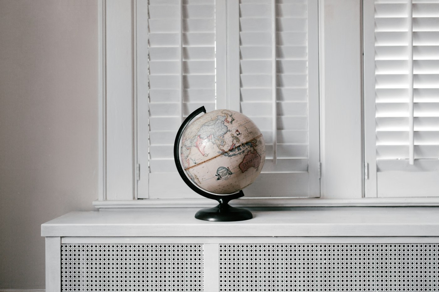 A desk globe on a white window sill in daylight
