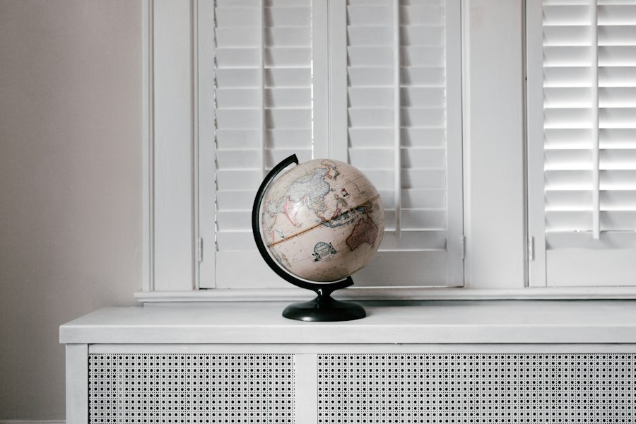 A desk globe on a white window sill in daylight