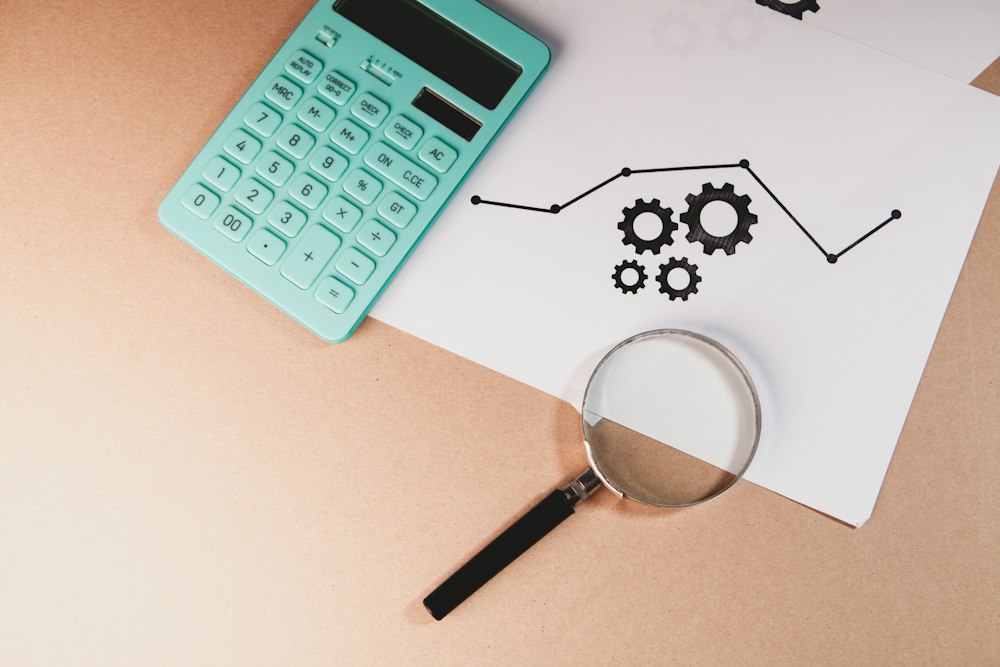 A magnifying glass and a calculator beside a printed growth chart