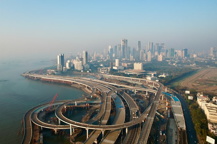 An aerial view of a Mumbai coastal road interchange and the city skyline