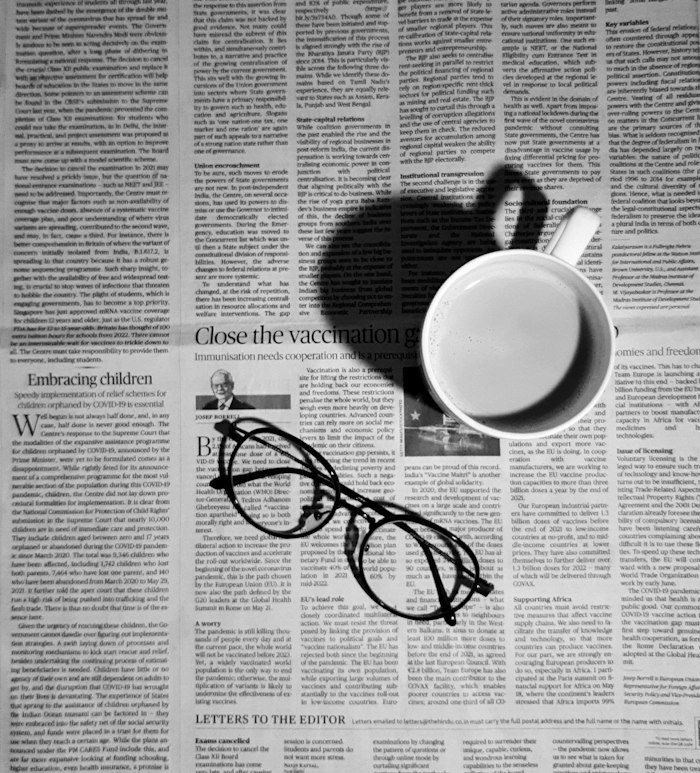 A newspaper, reading glasses and a cup of coffee on a table