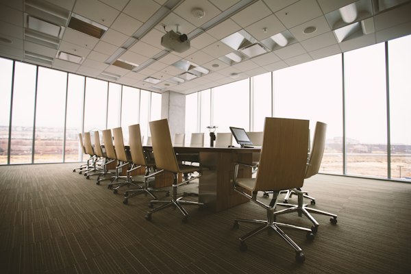 An empty boardroom with a long table and daylight windows