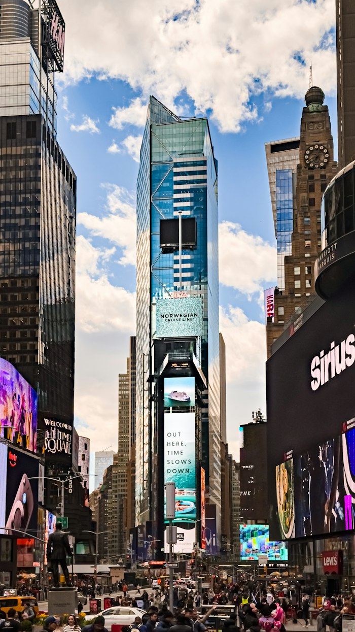 Times Square towers under a blue sky