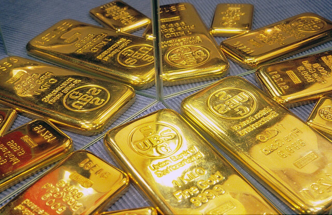Rows of stamped gold bars, brightly lit and reflected in mirrors