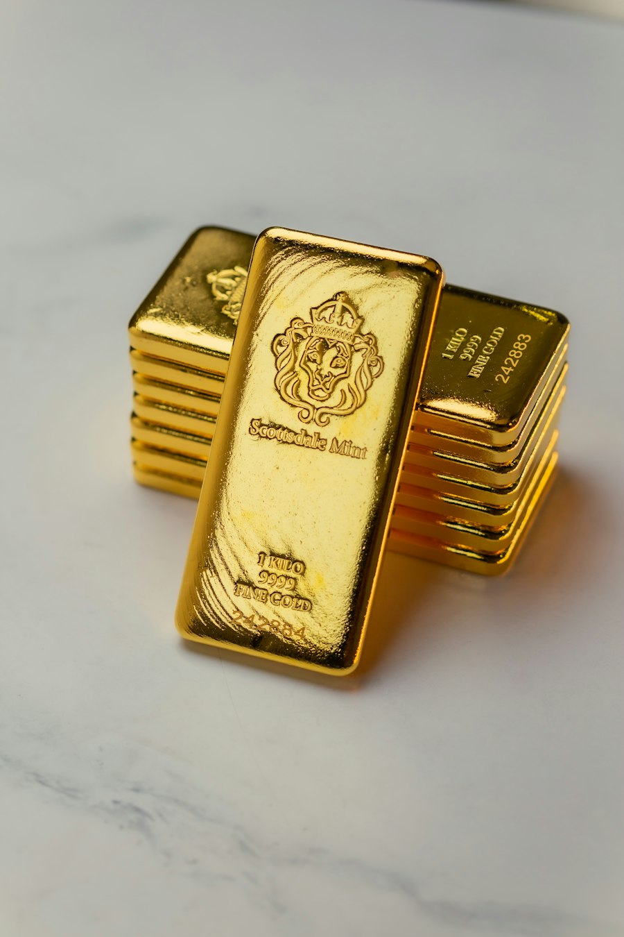 Gold bars standing on a white surface