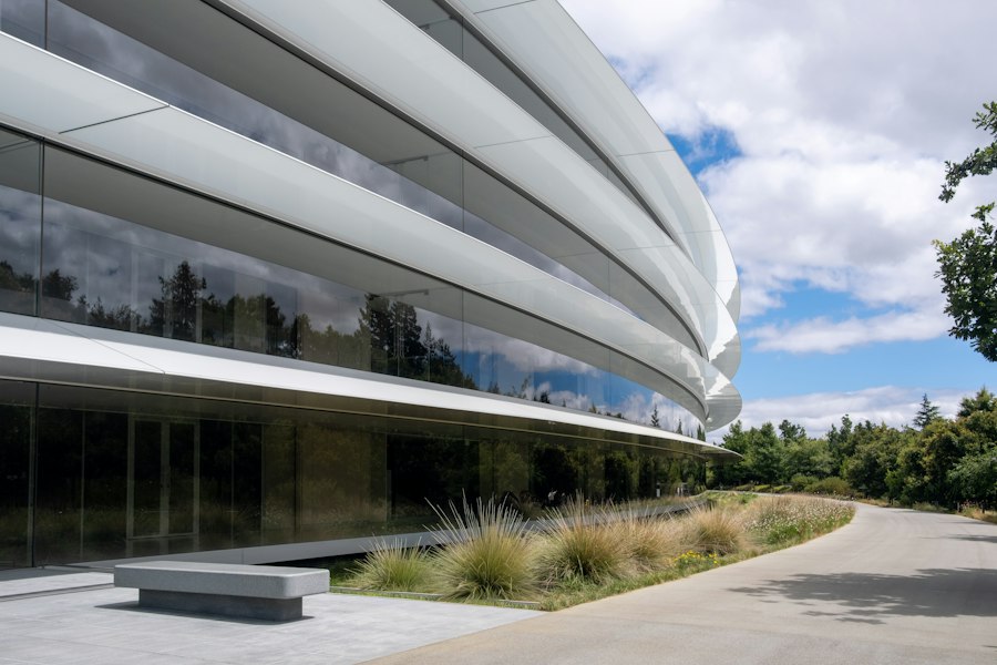 A curved glass company campus among trees in daylight
