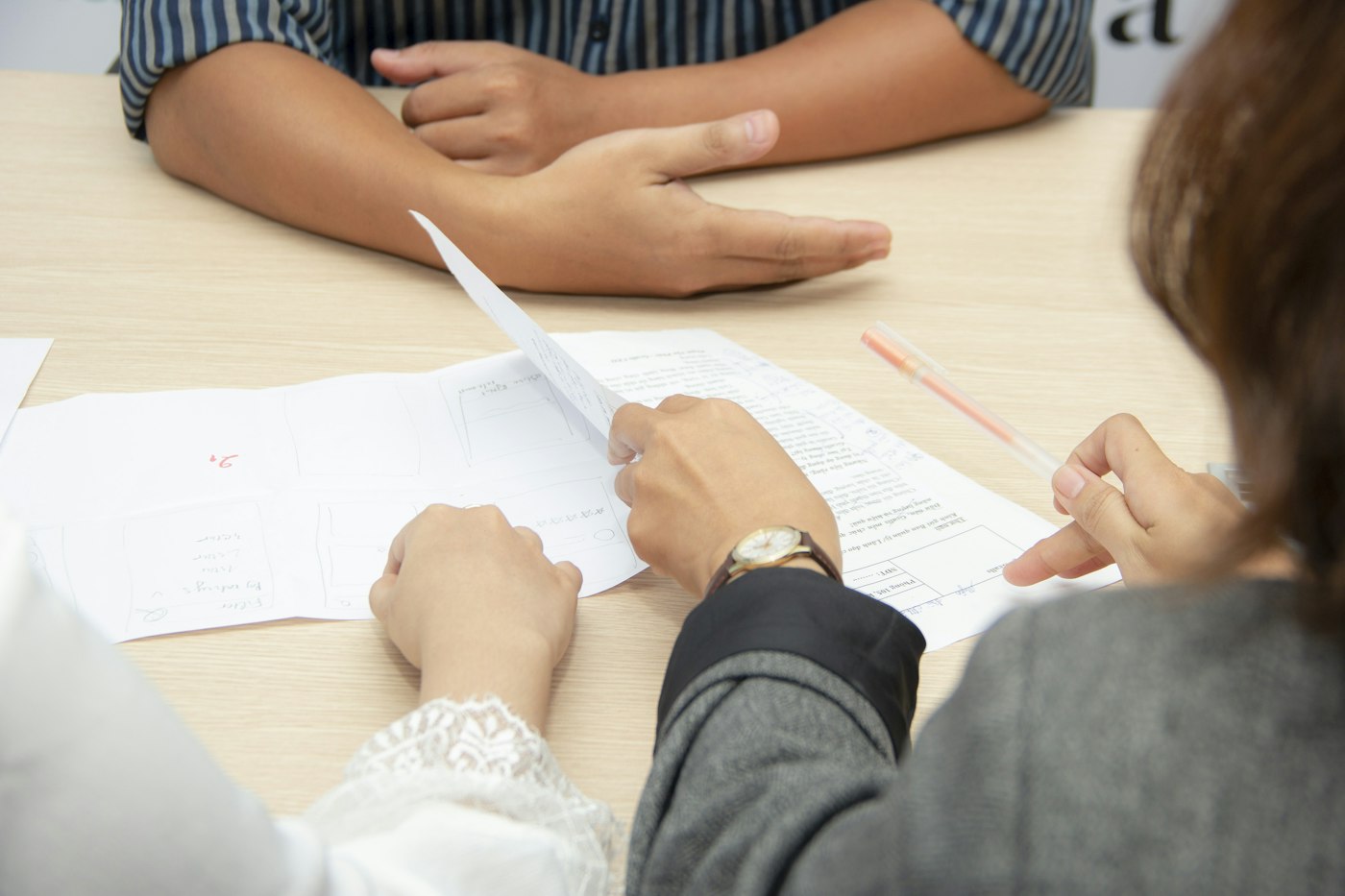 Two people going through documents together at a white table